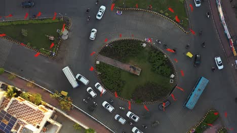 Aerial-drone-view-phone-camera-upwards-showing-lots-of-traffic-on-the-circle-and-lots-of-four-wheelers-and-buses-going