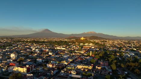 Drone-rising-over-the-cityscape-of-San-Andres-Cholula,-golden-hour-in-Mexico