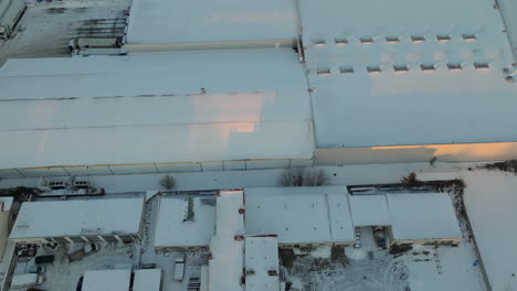 Snow-blankets-the-rooftops-of-buildings-in-Dąbrowa,-Gdynia,-with-the-soft-hues-of-dawn-reflecting-off-the-white-surfaces,-creating-a-quiet-and-tranquil-urban-winter-scene