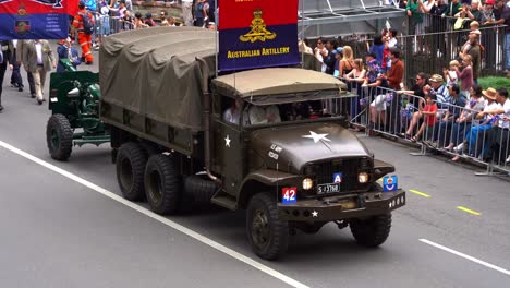 The-traditional-Anzac-Day-parade-proceeds-down-Adelaide-Street,-the-Royal-Regiment-of-Australian-Artillery's-'A'-Field-Battery-marches-behind-a-military-vehicle,-honouring-those-who-served-in-the-war