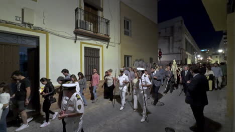 Crowd-of-people-Spanish-side-street-at-night-in-parade-fancy-clothes-at-night