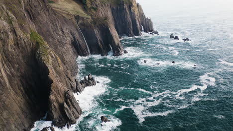 Pacific-Ocean-waves-crashing-against-Oregon-Coast-cliffs,-static-aerial