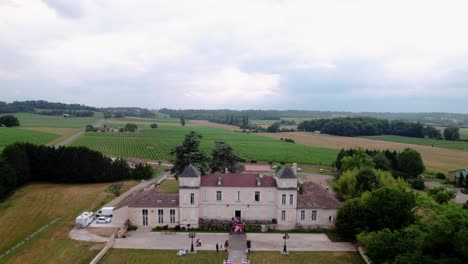 Aerial-closing-shot-of-wedding-guests-waving-on-the-steps-of-a-villa-in-Bordeaux