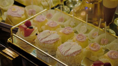 Nahaufnahme-Einer-Abwechslungsreichen-Auswahl-An-Kuchen-Auf-Basis-Von-Vanillecreme-Mit-Erdbeeren,-Lutschern,-Cupcakes-Und-Tiramisu