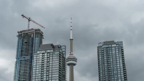 Construction-crane-by-skyscrapers-in-Toronto-on-cloudy-day,-timelapse
