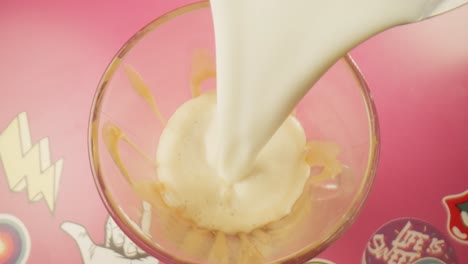 Pouring-steamed-hot-milk-over-vanilla-ice-cream-top-view-Milkshake