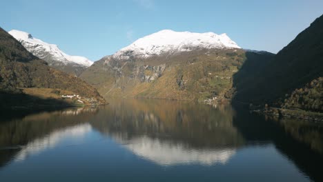 Ruhiges-Wasser-Des-Geirangerfjords-Mit-Schneebedeckten-Bergen,-Die-Sich-In-Norwegen-Spiegeln,-Heitere-Naturszene