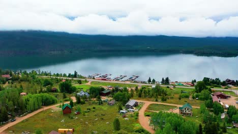 Aerial-Drone-View-of-Beautiful-Mountain-Lake-with-Rolling-Coulds-in-the-Background-and-Glass-Calm-Reflective-Water-on-Shadow-Mountain-Reservoir-and-Grand-Lake-Along-the-Overcast-Colorado-Shoreline