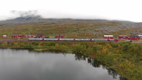 Aerial:-swedish-passenger-train-by-a-lake-in-northern-Sweden