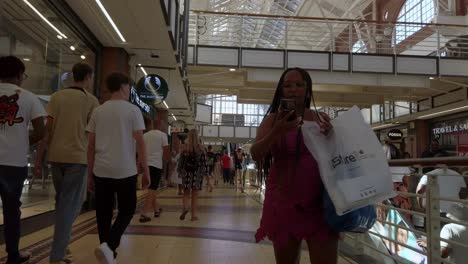 Shoppers-people-buy-inside-cape-town-shopping-mall-market-in-modern-architecture-city-of-south-africa,-persons-of-different-races-share-living