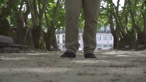 Close-up-shot-of-a-man-walking-closer-to-the-camera,-with-only-the-lower-legs-visible