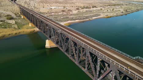 Large-Steel-Bridge-Crossing-Over-The-Colorado-River,-I-40-freeway-East,-Establshing-Aerial-Shot