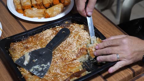 Close-up-view-of-a-knife-cutting-traditional-baklava-into-peaces