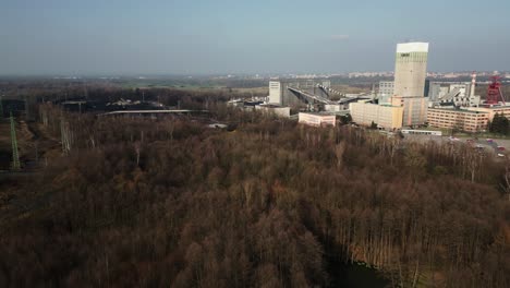 Aerial-view-of-Darkov-coal-shaft-surrounded-by-forest,-Czech-Republic