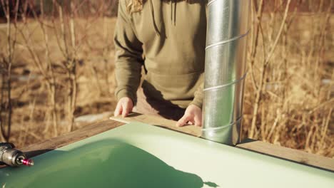 A-Man-is-Placing-a-Small-Plank-Into-the-Corner-of-the-DIY-Hot-Tub-Basin---Close-Up