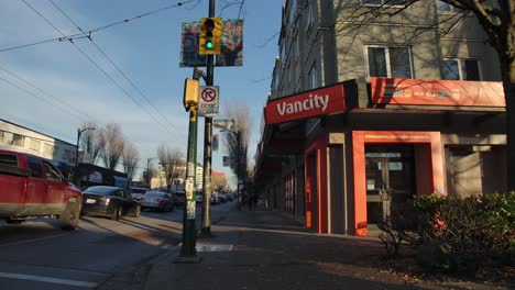 Observing-a-Flow-of-Congested-Vehicles-Passing-by-the-Vancity-Bank-in-East-Vancouver,-British-Columbia,-Canada---Wide-Shot