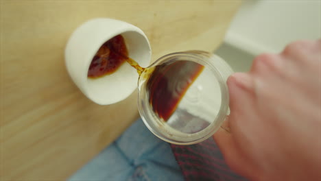 First-person-view-pouring-coffee-into-a-white-mug,-dynamic-angle