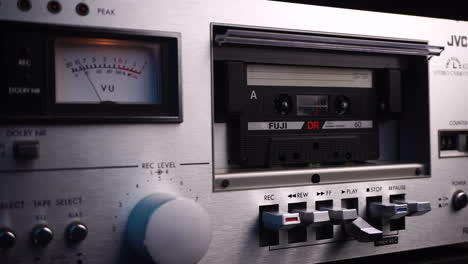 Audio-Cassette-Tape-on-Playback-in-Vintage-Deck-Player-with-VU-Meter-From-1980's