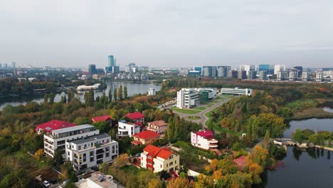 Residential-area-with-modern-skyline-north-of-bucharest,-autumn-colors,-cloudy-day,-serene,-aerial-view