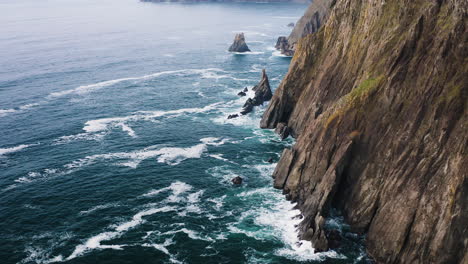 Steep,-rocky-coastline-of-Oregon-Coast-on-Pacific-Ocean,-slow-aerial-flyover