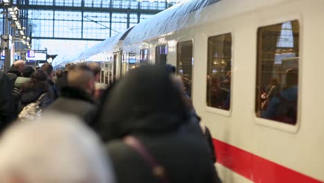 Verschwommene-Reisende-Auf-Einem-Belebten-Bahnsteig-Mit-Einem-Zug-Während-Der-Hauptverkehrszeit,-Weicher-Fokus