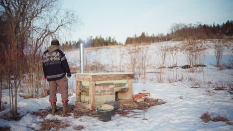 Hombre-Construyendo-Un-Jacuzzi-De-Bricolaje-Fuera-De-Su-Cabaña-En-Invierno