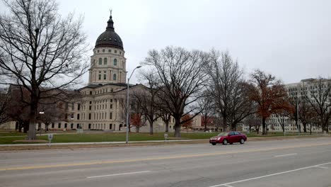 Kansas-state-capitol-building-in-Topeka,-Kansas-with-vehicles-driving-by-and-stable-video