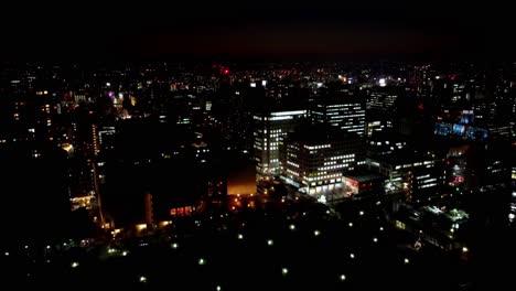 Nächtliches-Stadtbild-Mit-Beleuchteten-Gebäuden-Und-Dunklem-Himmel,-Pulsierendes-Urbanes-Nachtleben,-Weite-Aussicht