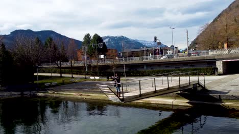 Tourist-Fotografiert-Auf-Einer-Fußgängerbrücke-In-Ebensee,-Traunsee-In-Der-Nähe,-Ruhige-Bergkulisse,-Sonniger-Tag