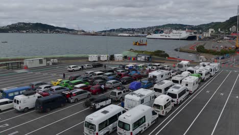 Vehículos-Coloridos-Alineados-En-La-Terminal-De-Ferry-Interislander-De-Wellington,-Nueva-Zelanda,-Día-Nublado,-Vista-Aérea