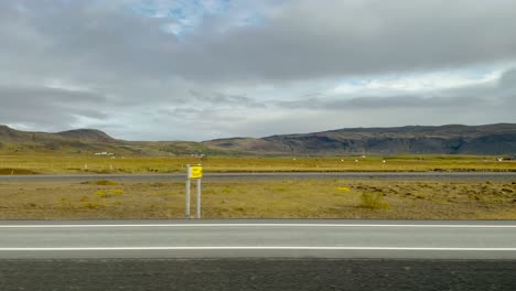 Campos-Verdes-Y-Montañas-En-Islandia-Nublada,-Punto-De-Vista-Desde-El-Coche-En-La-Carretera