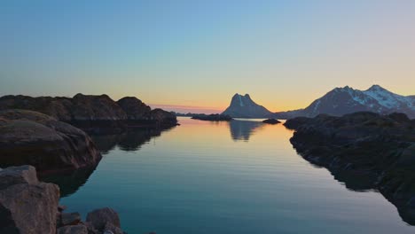 Cliff-islands-near-rocky-coast-with-snowy-mountains-in-the-background