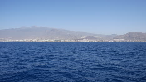 Ocean-view-with-mountainous-coastline-in-the-distance,-clear-blue-sky