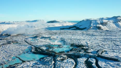 Vista-Desde-Un-Dron-De-Alta-Calidad,-La-Laguna-Azul-En-Reykjavik,-Islandia,-Parece-Una-Hermosa-Piscina-Azul-En-Medio-De-Un-Terreno-Rocoso,-Con-Pequeñas-Casas,-Caminos-Y-Hermosos-Paisajes-Cercanos.