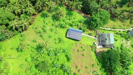 Vista-Aérea-De-Una-Casa-En-Medio-Del-Bosque-Con-Un-Sistema-Solar-En-El-Techo,-Santo-Tomé,-África