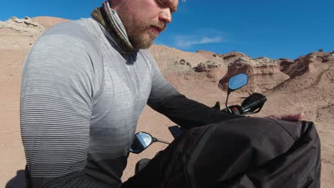 Young-Caucasian-motorcyclist-takes-a-travel-break-in-eroded-badlands