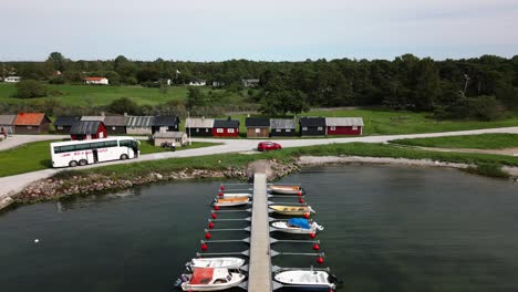 small-harbor-with-many-small-boats,-small-village,-ocean,-visby,-sweden,-drone