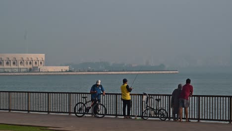 Residents-fishing-during-a-misty-morning-at-Khalid-Lagoon-in-Sharjah,-United-Arab-Emirates