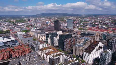 Oslo,-Norway,-Flying-Above-Apartment-Buildings-in-Central-District-Near-Train-Station-and-Fjord,-Drone-Shot