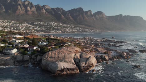 Boulders-At-Bakoven-Beach-With-Twelve-Apostles-Mountains-In-The-Background-In-Camps-Bay,-Cape-Town,-South-Africa