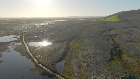 Panorama-Umlaufbahn-Aus-Der-Luft-Um-Dramatische-Überschwemmungsgebiete-Im-Irischen-Burren,-Während-Das-Sonnenlicht-Auf-Dem-Wasser-Glitzert