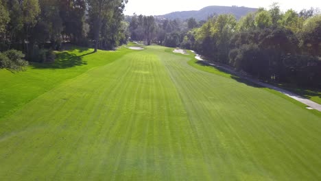 4K-Aerial-Drone-View-of-Calabasas-Country-Club-in-Los-Angeles,-California-with-Lush-Fairways-and-White-Sand-Bunkers-on-a-Warm,-Sunny-Day