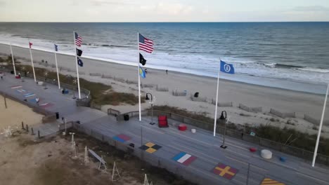 Banderas-Erguidas-En-El-Paseo-Marítimo-De-Myrtle-Beach-Vista-Aérea-Giratoria