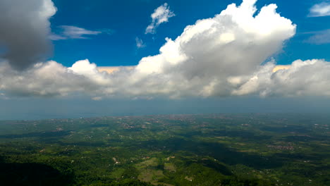 Hyperlapse-timelapse-of-abstract-white-clouds-moving-in-blue-sky-over-Bali-verdant-landscape,-Indonesia