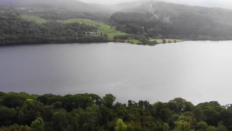 Luftaufnahme-Der-Ruhigen-Oberfläche-Des-Loch-Tummel-Mit-Rollenden-Nebelschwaden-Im-Hintergrund-über-Den-Talhügeln