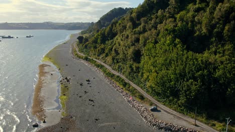 Aerial-view-following-the-coastline-of-Tenaun,-golden-hour-in-Chiloe,-Chile