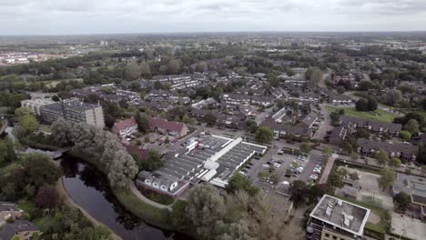 Aerial-approach-of-shopping-mal-car-parking-lot-in-Dutch-residential-neighbourhood