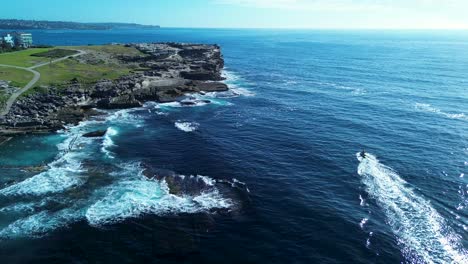 Avión-Teledirigido-De-Salvavidas-En-Moto-Acuática-De-Rescate-Alrededor-Del-Promontorio-Acantilado-Rocoso-Paisaje-Punto-Motos-Acuáticas-Deportes-Bahía-Maroubra-Sydney-Bondi-Australia