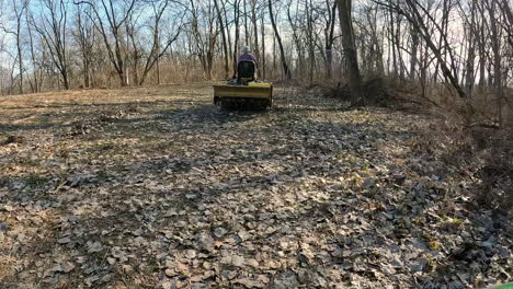 POV---Following-a-man-driving-utility-tractor-with-an-attached-rototiller-to-a-wildlife-food-plot-on-edge-of-woods