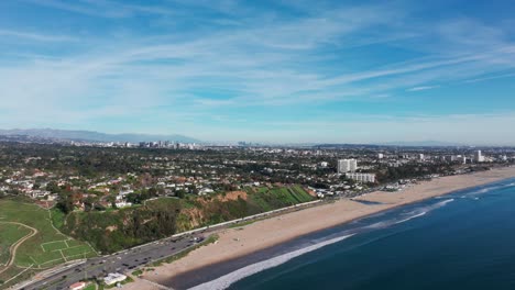 Drone-aerial-shot-flying-towards-santa-monica,-California-with-LA-skyline